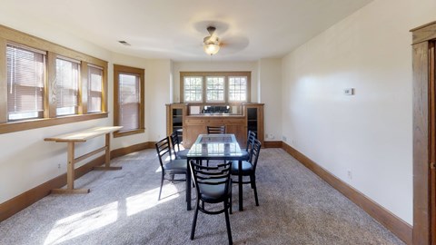 A dining room with a table and chairs.