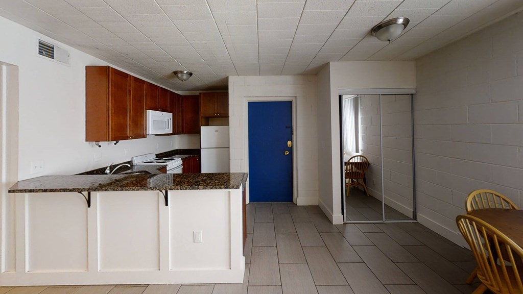 A kitchen with a blue door and white cabinets.