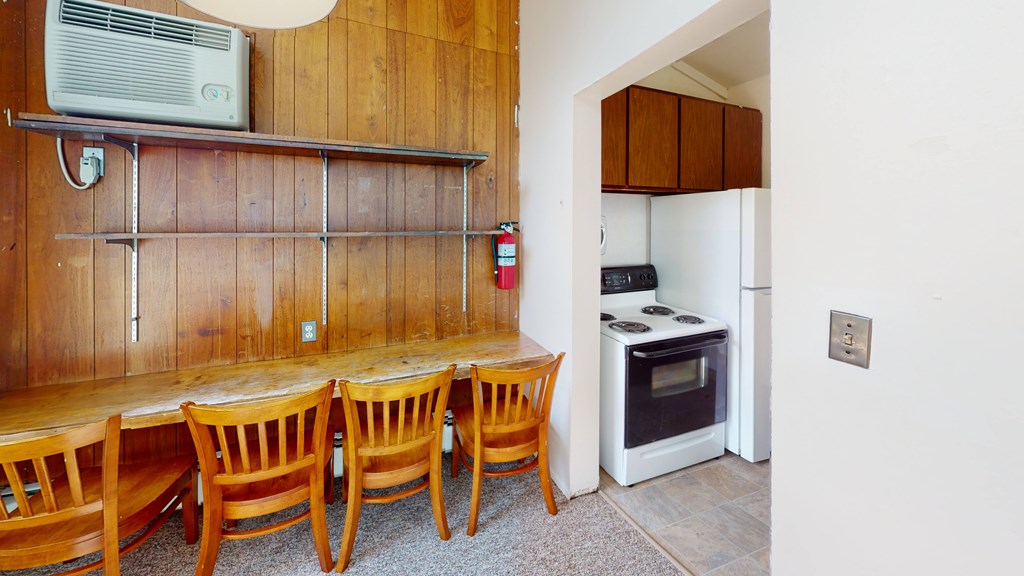 A kitchen with a table and chairs.