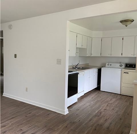 A kitchen with white cabinets and a black oven.