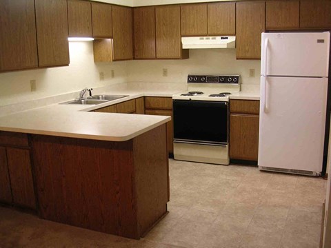 a kitchen with white appliances and wooden cabinets