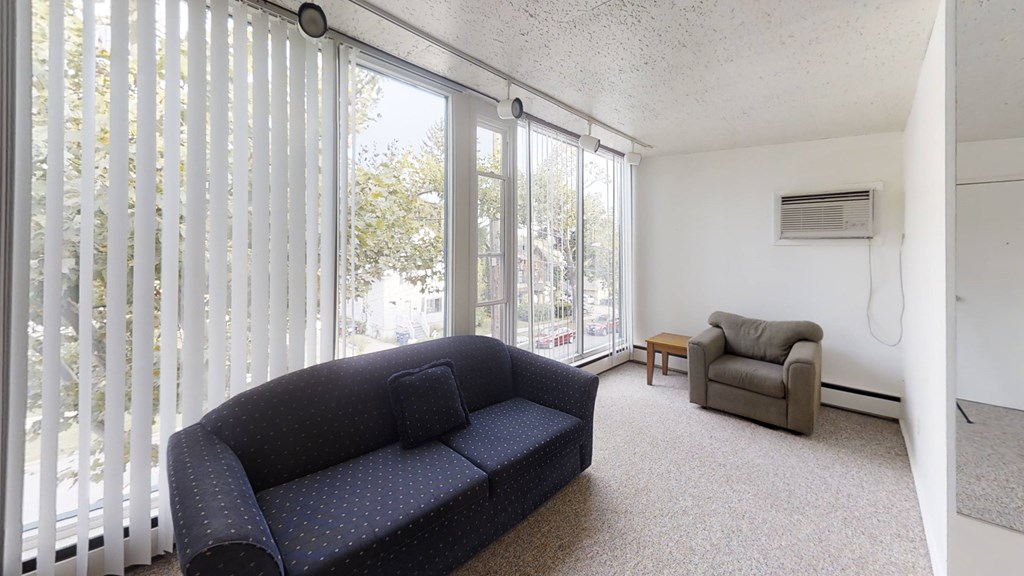 A living room with a blue couch and a chair.
