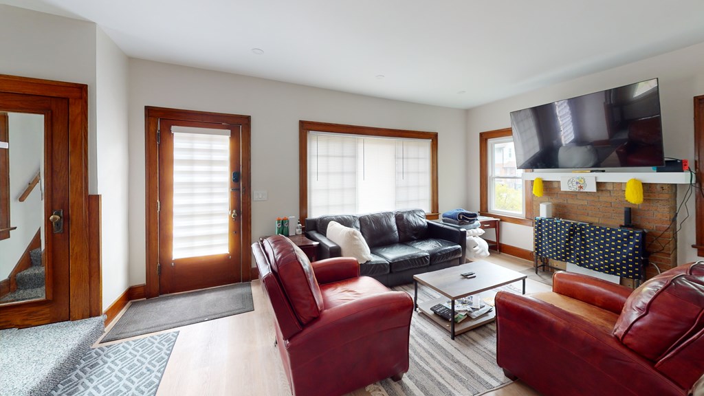 A living room with red leather chairs and a black couch.