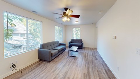 A living room with a grey couch and a black coffee table.