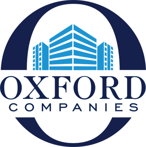 The image is a logo of Oxford Companies featuring a building and text.