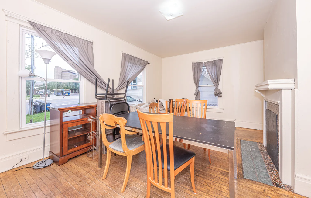 A room with a table and chairs and a fireplace.