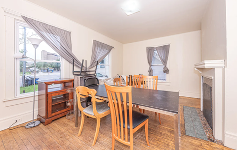 A room with a table and chairs and a fireplace.