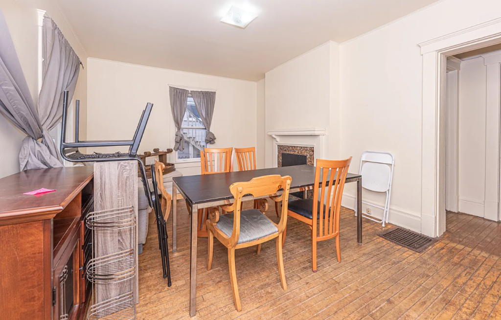 A dining room with a table and chairs.