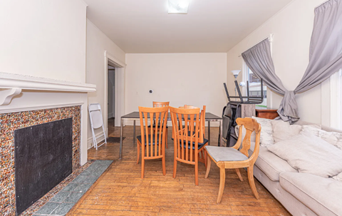 A living room with a fireplace and a dining table set up.