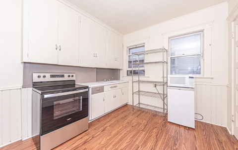 A kitchen with white cabinets and a black stove top oven.
