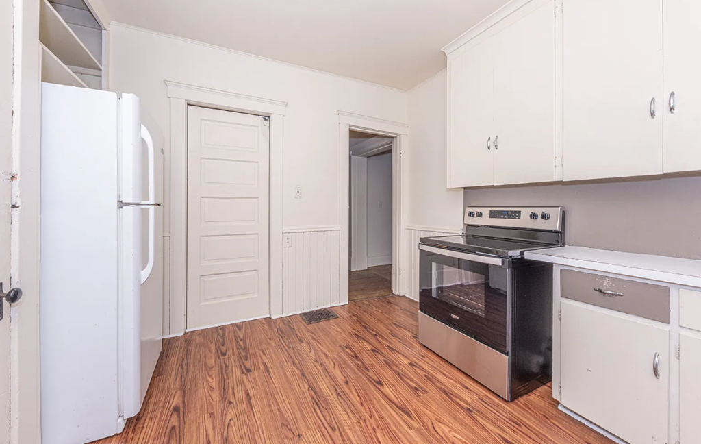 A kitchen with a white fridge, stove, and cabinets.