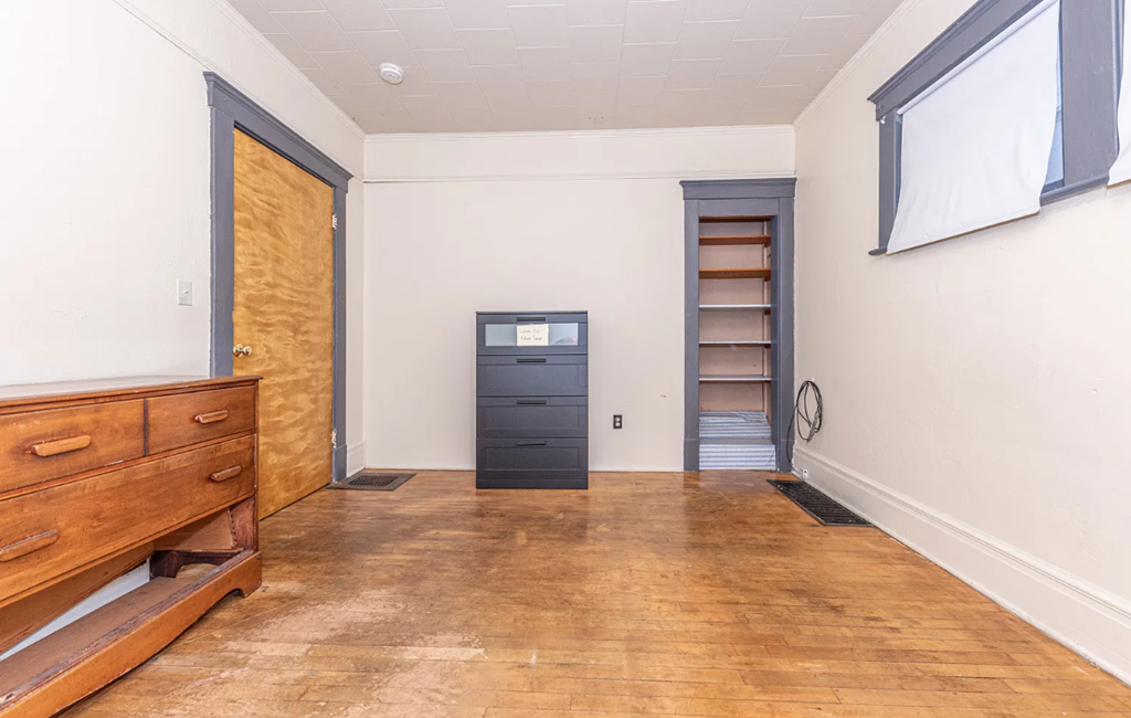 A room with a wooden floor and a brown door.