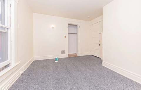 A room with a grey carpet and a white door.