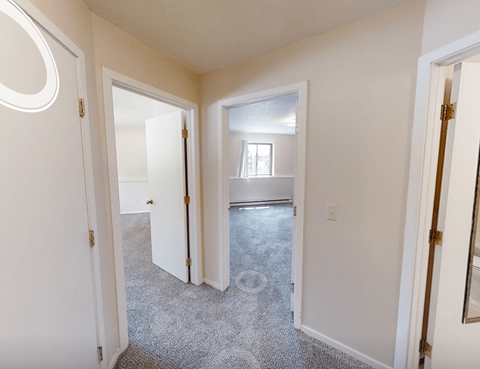 A room with a carpeted floor and a window.