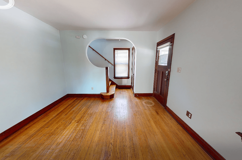 A room with wooden floors and a staircase.