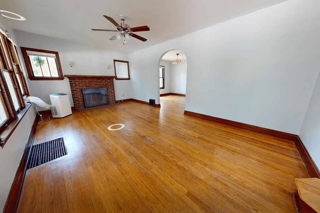 A room with a fireplace and a fan.