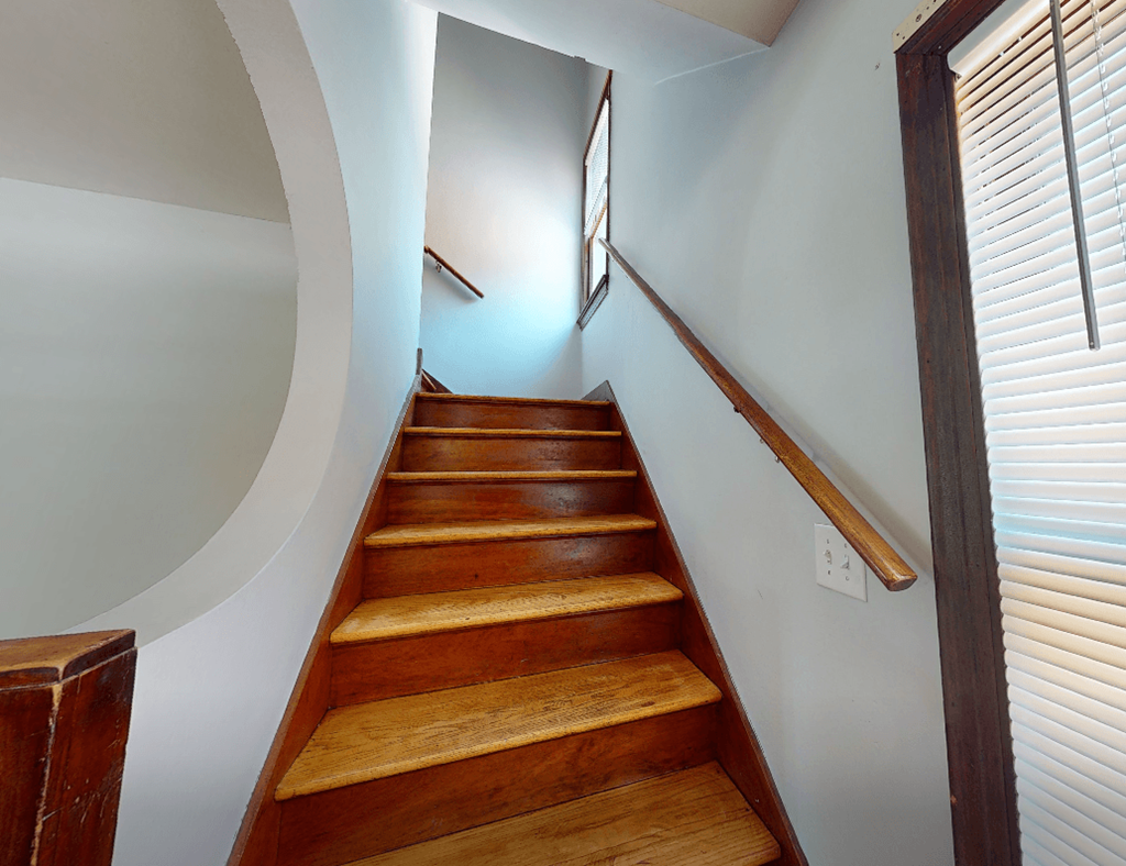 A staircase with wooden steps and a handrail.