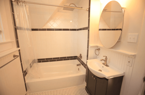 A white sink is next to a bathtub in a bathroom.