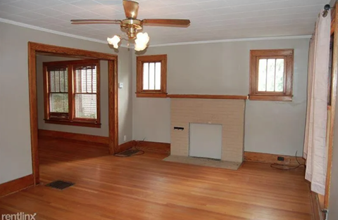 A room with wooden floors and a fireplace.