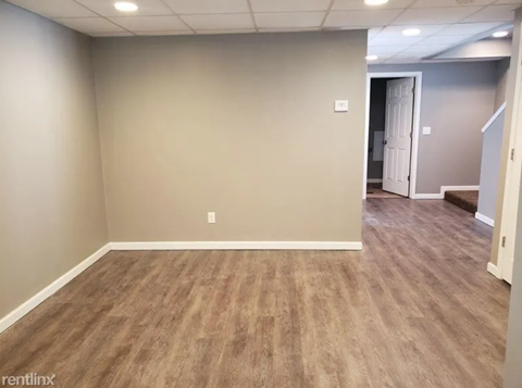 A room with light brown flooring and white walls.