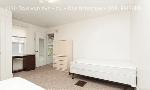 A bedroom with a bed, dresser, and wardrobe in a property located at 1130 Oakland Ave, unit #4.