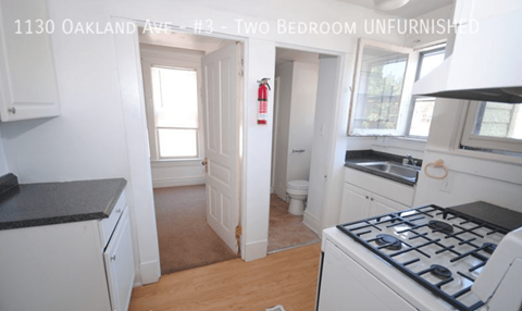 A kitchen with a stove top oven and a fire extinguisher on the wall.