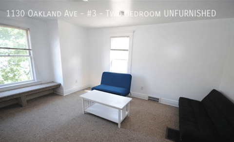 A living room with a blue chair and a white coffee table.