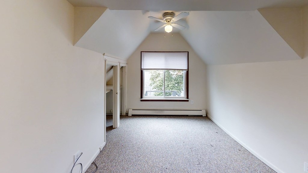 A room with a window and a ceiling fan.