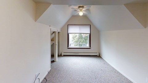A room with a window and a ceiling fan.