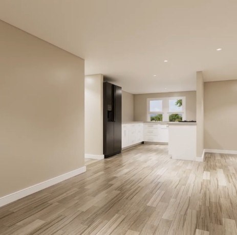 A kitchen with a black refrigerator and wooden flooring.