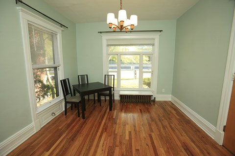 A room with a wooden floor and a table with two chairs.