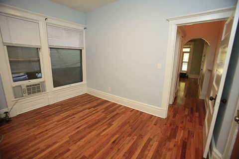 A room with a window and wooden floors.