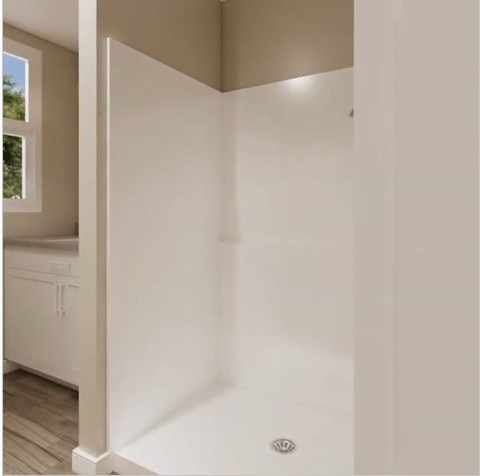 A white bathroom with a window and a sink.