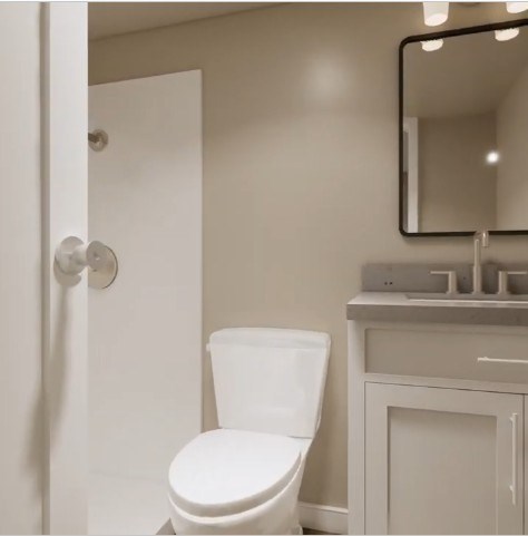 A white toilet sits next to a sink in a bathroom.