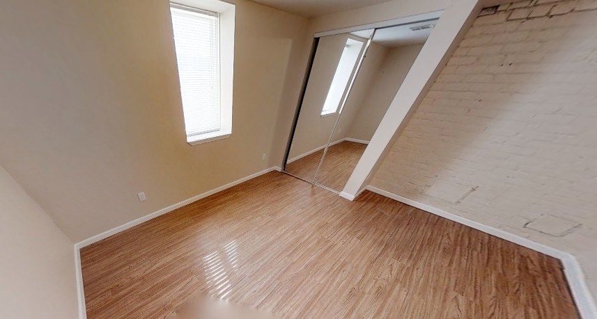 A room with wooden flooring and a window.