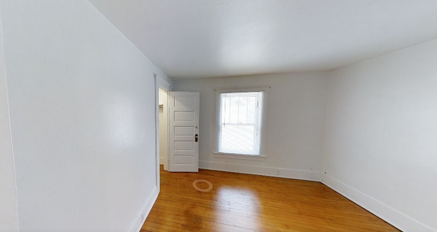 A room with a wooden floor and a small window.