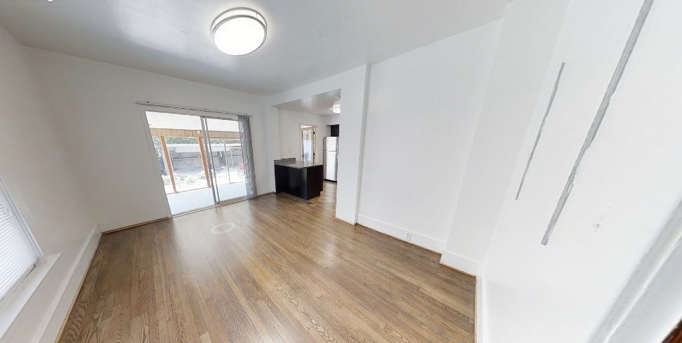 A room with wooden flooring and white walls.