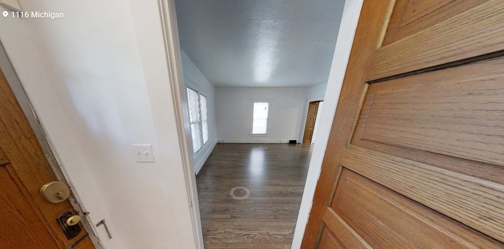 A view of a hallway with a wooden door on the right.