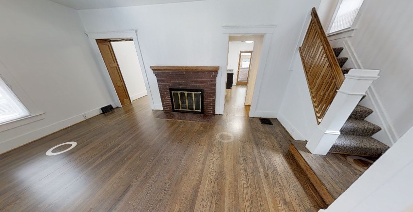 A room with wooden floors and a staircase.