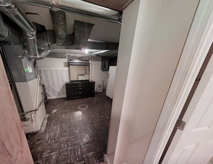 A room with a brown floor and white walls.