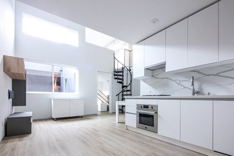 a large white kitchen with white cabinets and a stainless steel stove