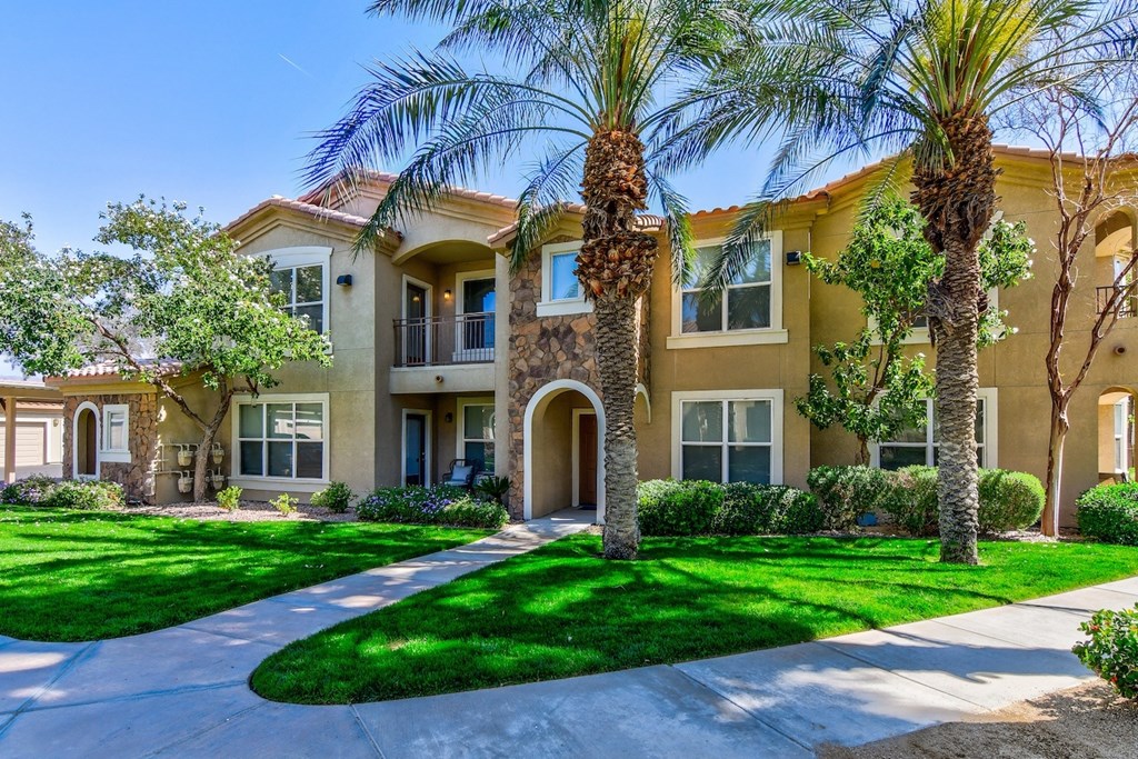 A row of houses with palm trees in front.
