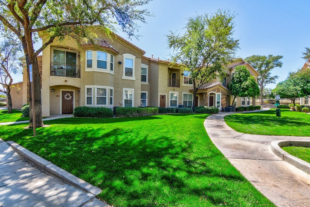 A row of houses with green lawns in front.
