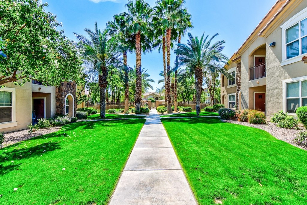 A row of houses with a green lawn in front.