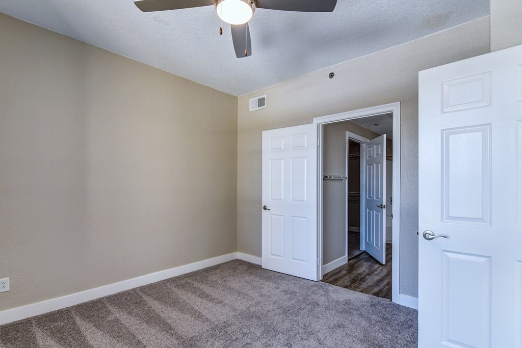 A room with a ceiling fan and a carpeted floor.