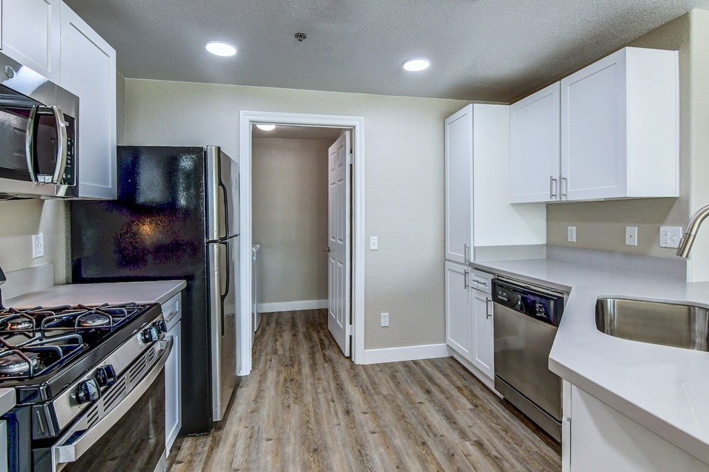 A kitchen with a black refrigerator, stove, and oven.