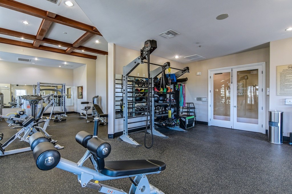 A well-equipped gym with a variety of exercise machines and weights.