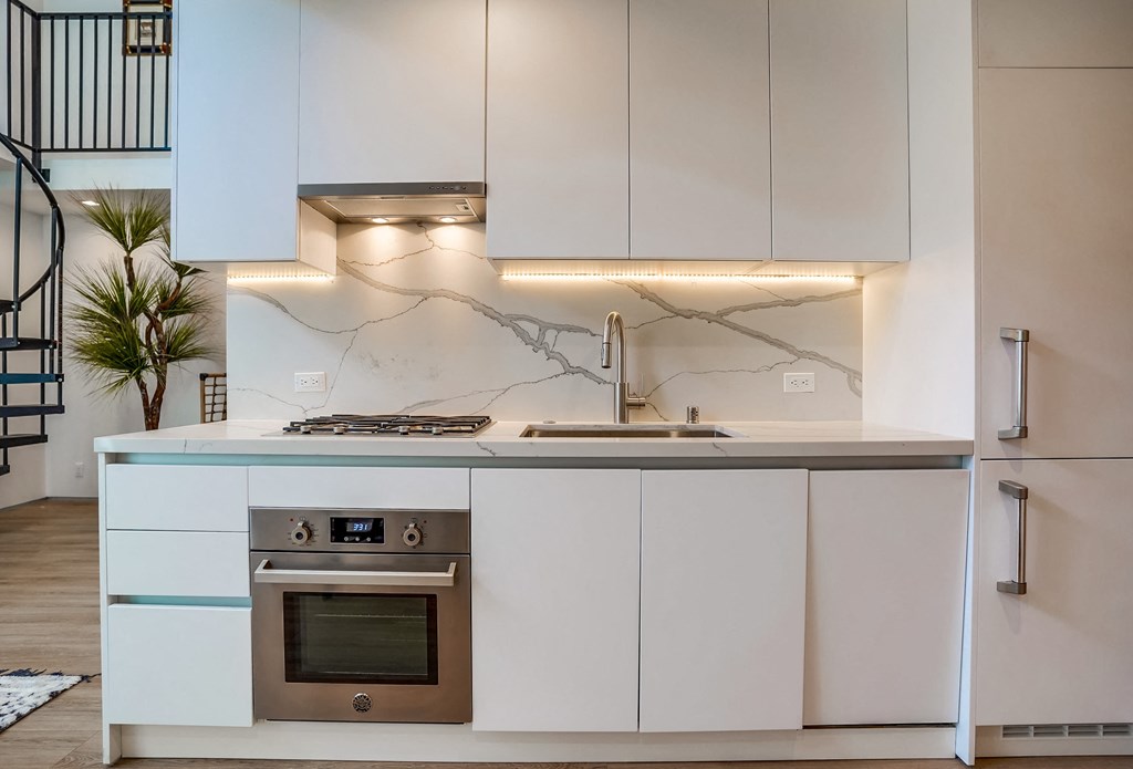 a kitchen with white cabinets and stainless steel appliances