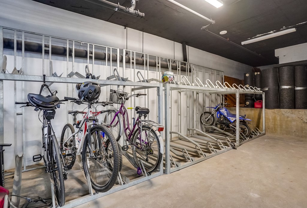 a bike rack with several bikes and helmets on it