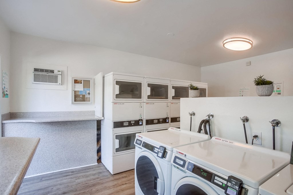 a laundry room with a washer and dryer and a counter with a sink